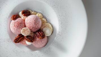 A dessert plate with macarons, pecans, and marshmallows.