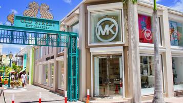 A storefront with a prominent 'MK' logo, a sign reading 'OLD STREET SINT MAARTEN', and a Michael Kors store.