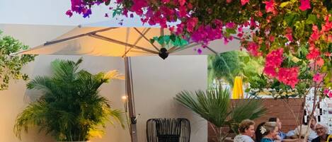 An outdoor seating area with a fire table, cushioned chairs, and potted plants.