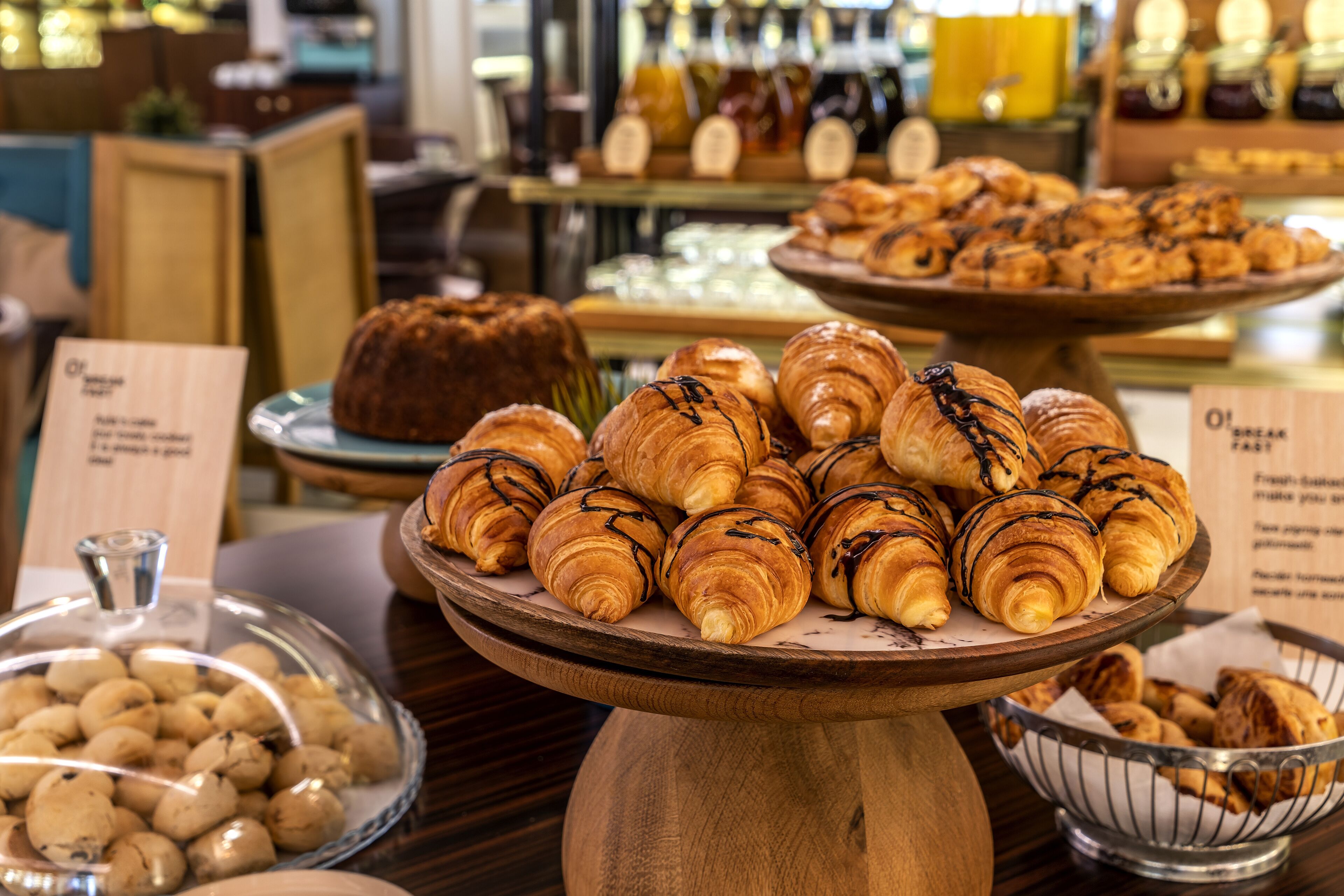 A bakery display with various pastries and a cake on a wooden stand.