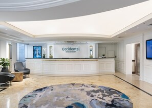 Welcome to the elegant lobby, featuring a spacious reception area with a comfortable seating area and a unique ceiling design.