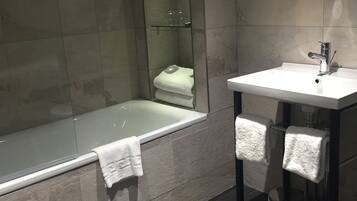 Ένα σύγχρονο μπάνιο με μπανιέρα, νιπτήρα και καθρέφτη.