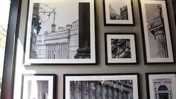 A wall with multiple framed black and white photographs of architectural structures.