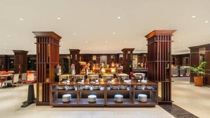 A buffet area with multiple serving stations and a variety of food items. - Swiss-Belhotel Borneo Banjarmasin (Banjarmasin)