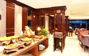 A buffet area with various food items, a plant, and a coffee machine. - Swiss-Belhotel Borneo Banjarmasin (Banjarmasin)