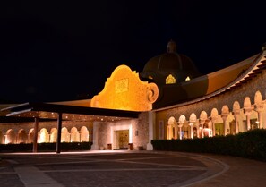 A hotel with a large entrance, a covered patio area, and a series of arches along the building's facade.