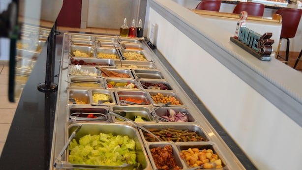 A buffet with various food items in metal containers. - Travelers Inn (Dayton)