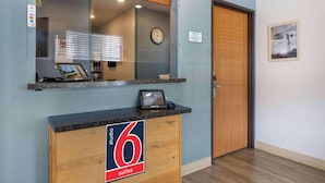 A hotel reception desk with a sign indicating '6 suites.' - Studio 6 Extended Stay Wichita South KS (Wichita)