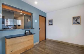 A reception area with a wooden counter, a clock, and a door.