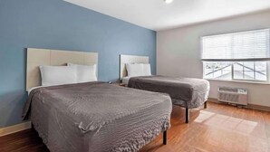 A hotel room with two beds, a large window, and a ceiling light. - Studio 6 Extended Stay Wichita South KS (Wichita)