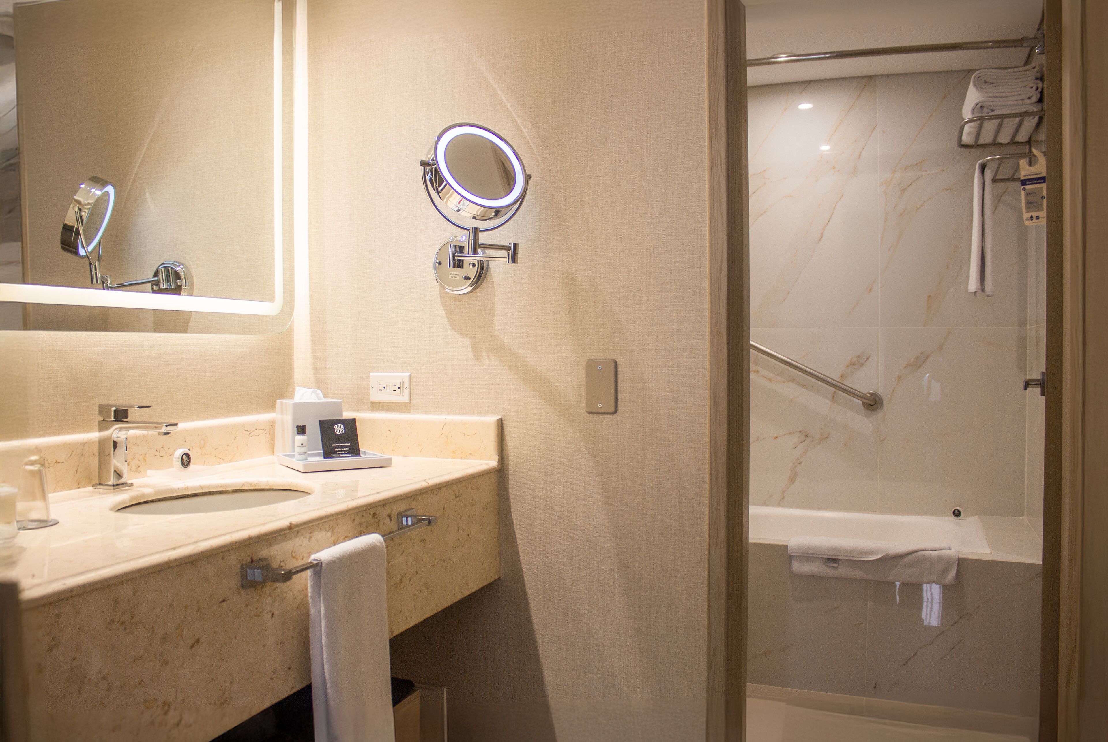 A bathroom with a sink, mirror, and a shower area.
