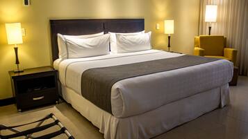 A hotel room with a large bed, two bedside tables with lamps, a chair, and a small table.