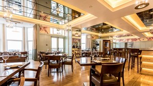 A spacious restaurant with high ceilings, large windows, and wooden flooring. - The Claremont  (Douglas)