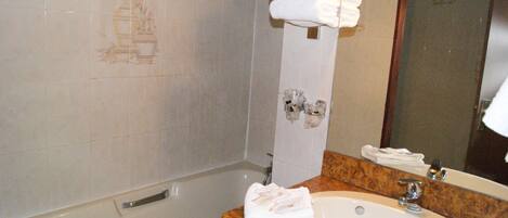 Un baño con lavamanos de mármol, un espejo y un perchero para toallas.