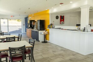 A restaurant interior with a counter, seating area, and a clock on the wall. - Signature Inn Branson (Branson)