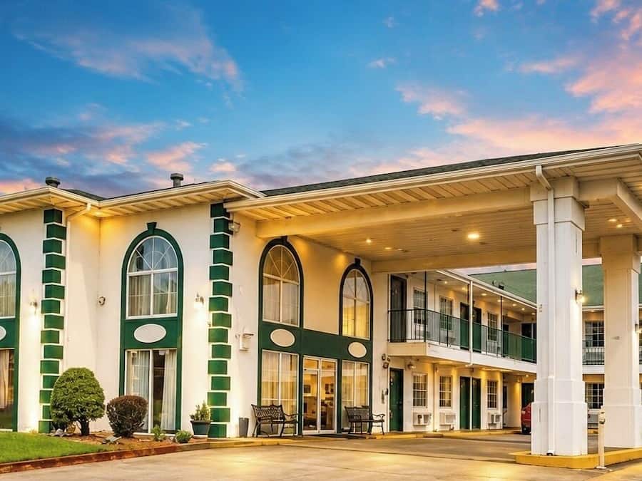 Ein Hotel mit zweistöckiger Bauweise, großen Fenstern und einer überdachten Außenbereich.