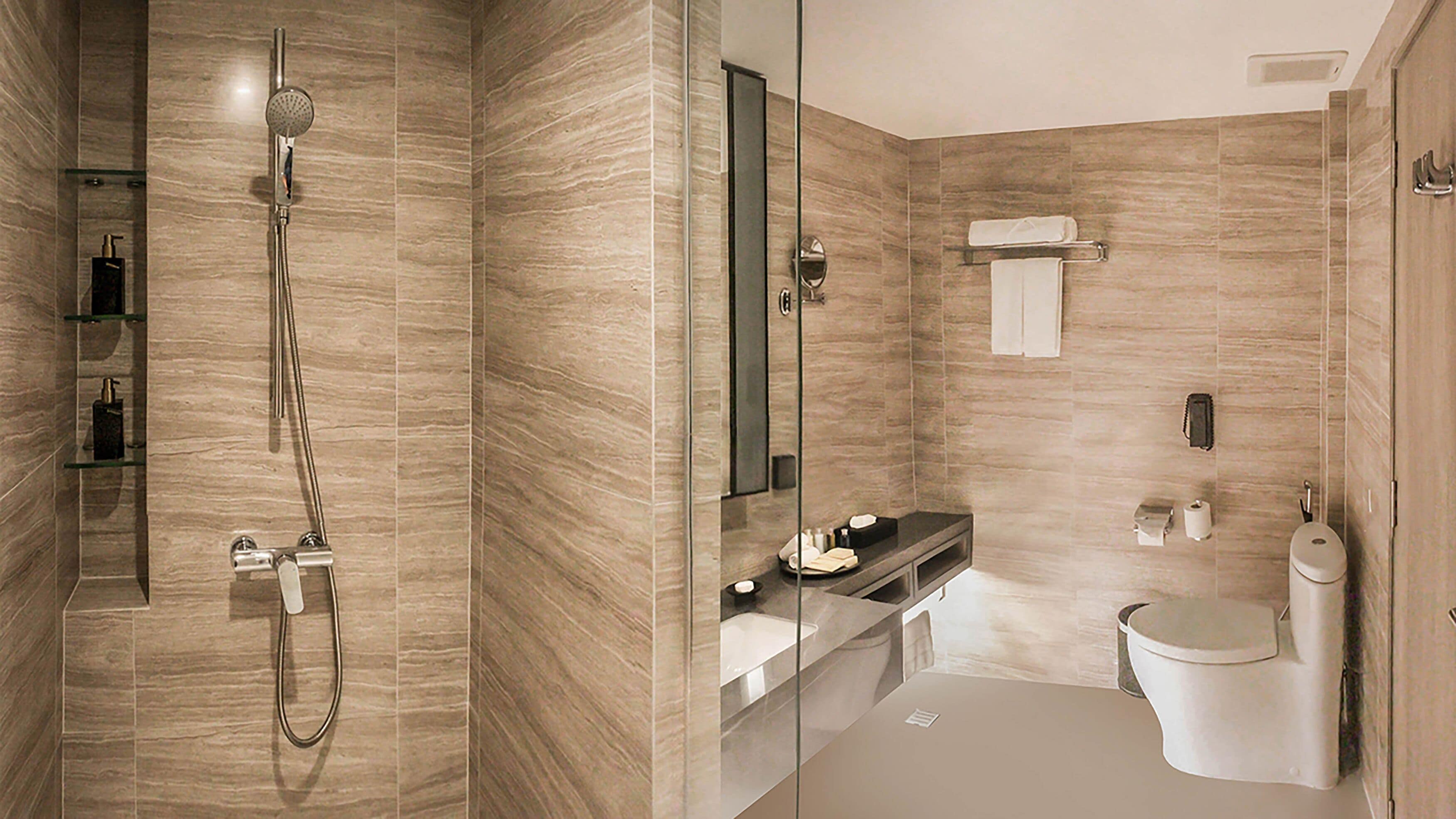 A modern bathroom with a glass-enclosed shower, a vanity with a sink, and a toilet.