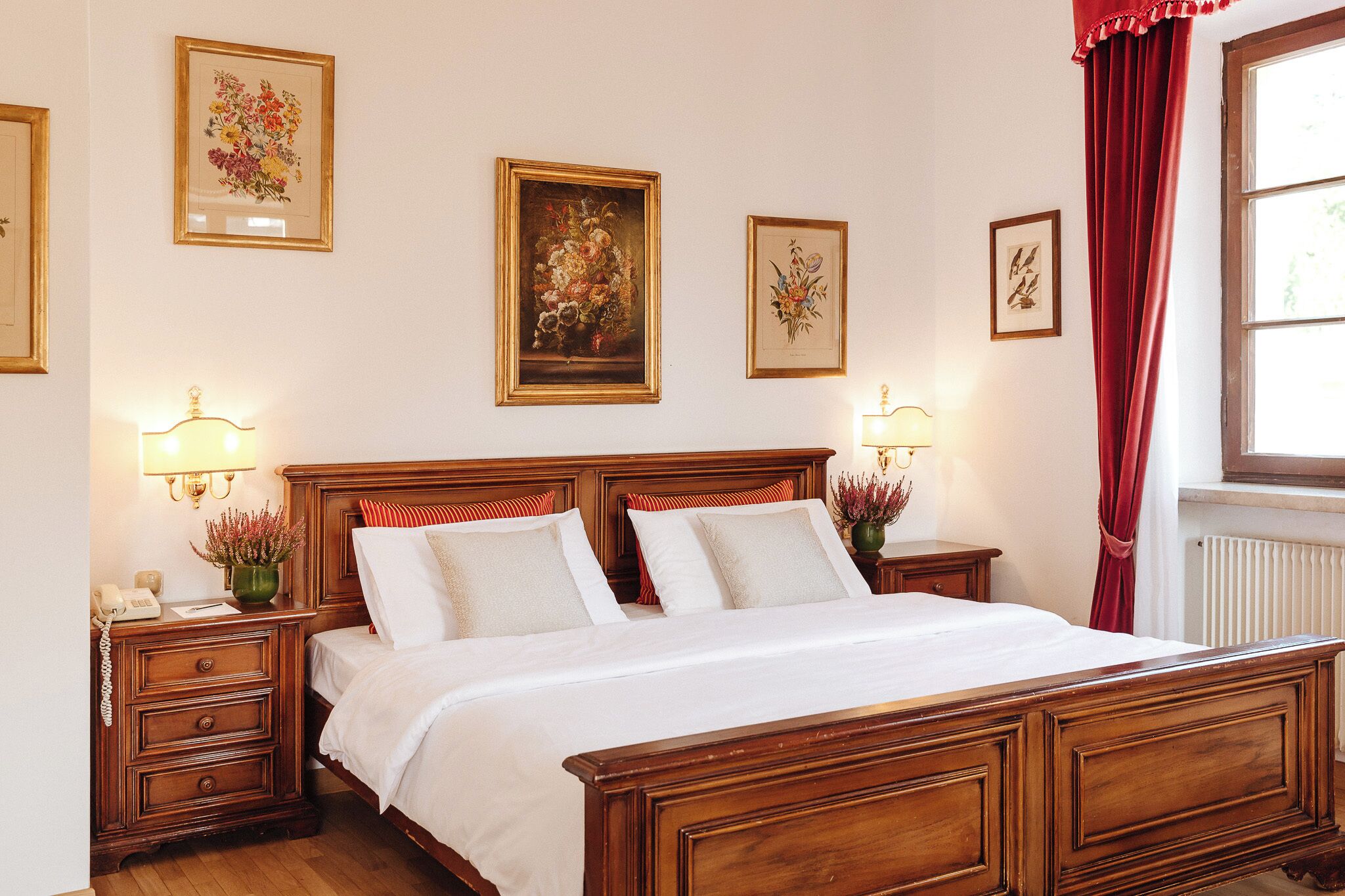 A neatly made bed with white linens, wooden headboard, and two bedside tables with lamps.