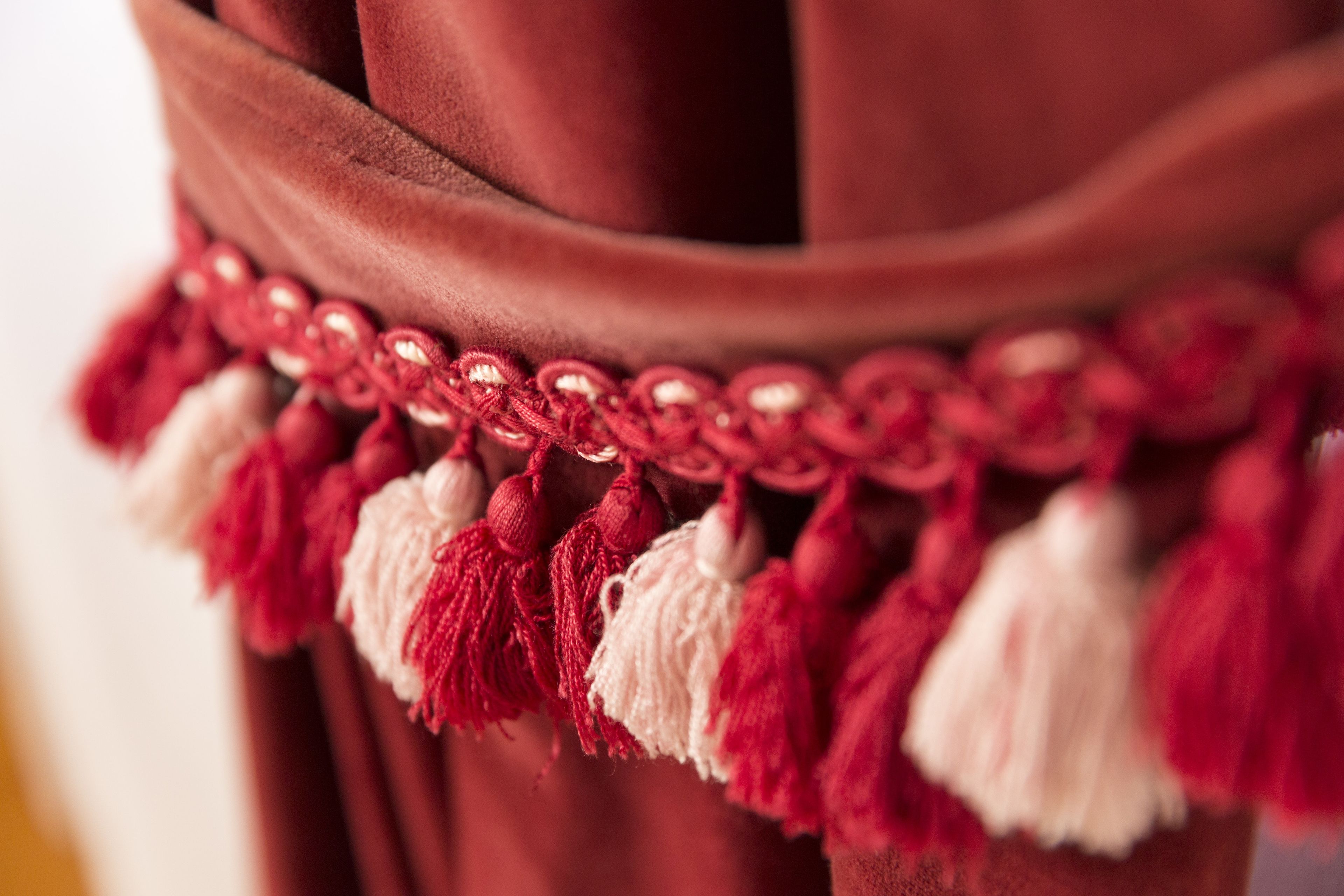 Nahaufnahme eines Stoffes mit roter und weißer Fransenbordüre.