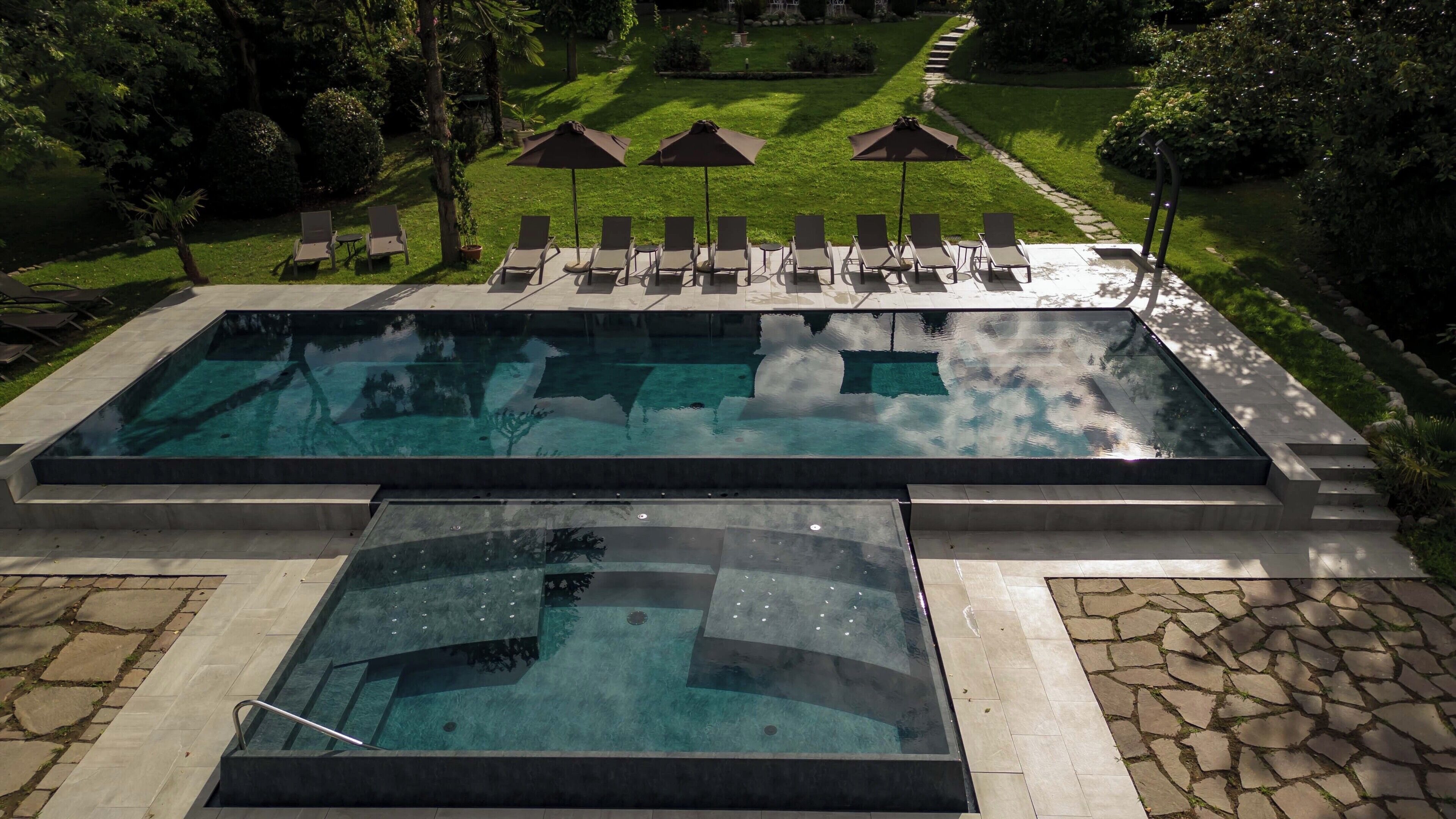 Una piscina cubierta, una piscina al aire libre, sombrillas, tumbonas