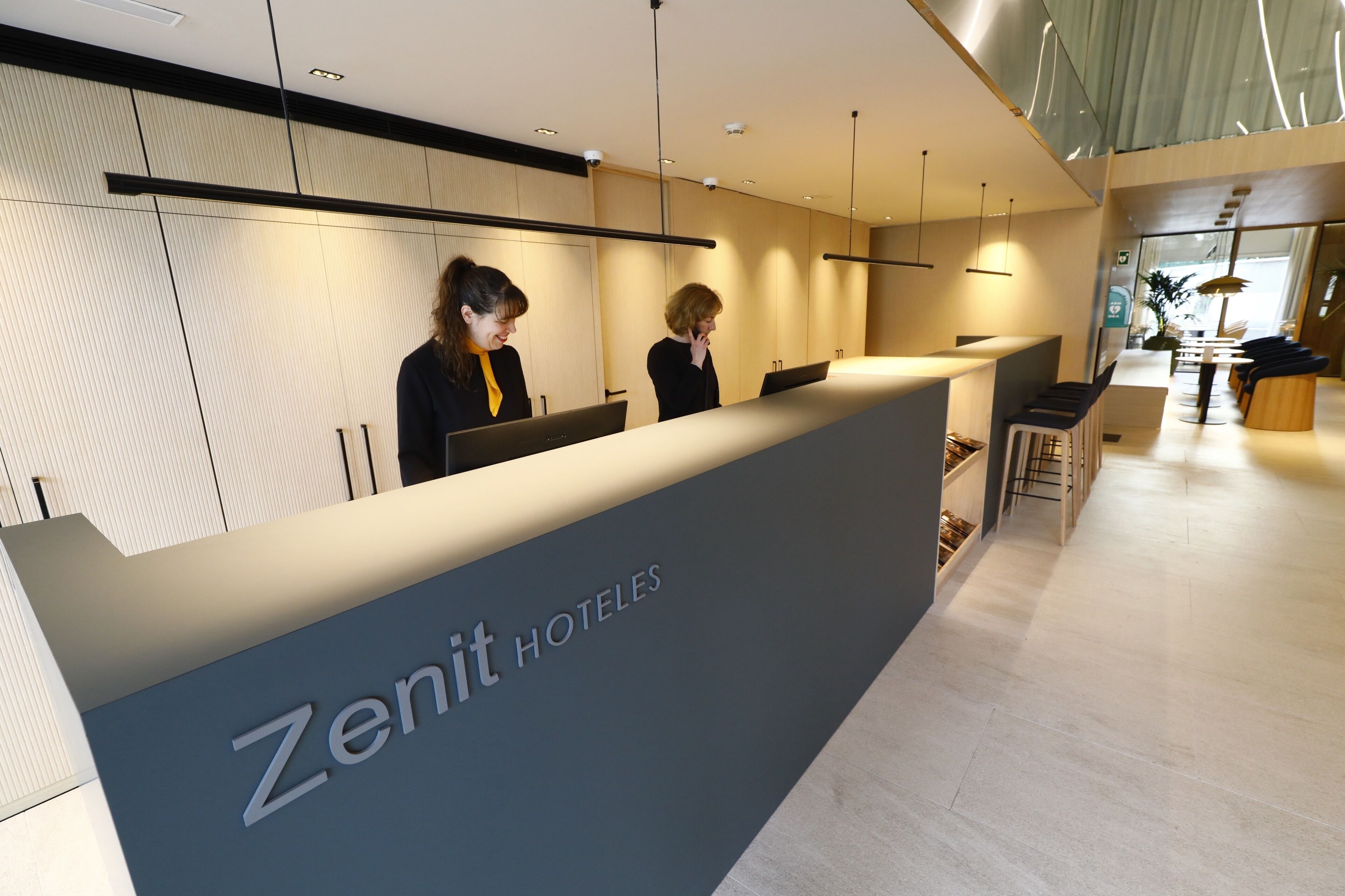 A reception desk with a sign reading "Zenit Hotels".