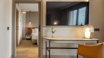 Una habitación de hotel con una cama, un escritorio con lámpara y un espejo.