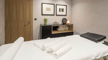 Relax in comfort with a neatly made bed, a cozy bench, and soothing ambiance.