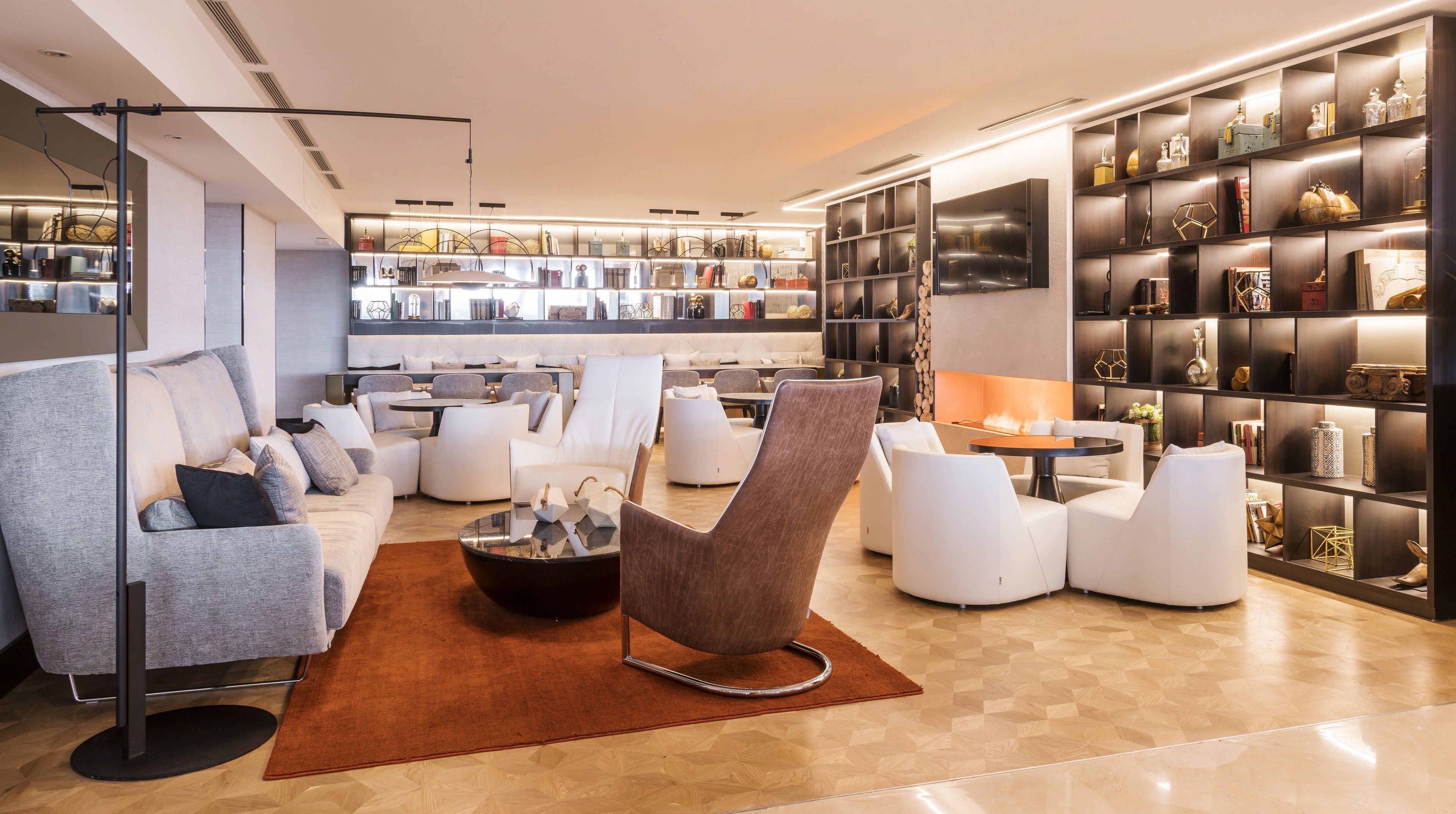 Una sala de estar moderna con sofá, sillones, una mesita de centro y una chimenea.