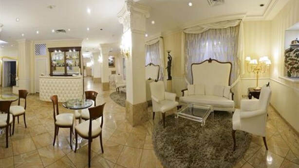 A spacious hotel lobby with a bar, seating area, and a round rug. - Zanhotel Tre Vecchi (Bologna)