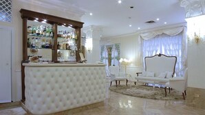 A luxurious room with a white bar, elegant furniture, and a chandelier. - Zanhotel Tre Vecchi (Bologna)