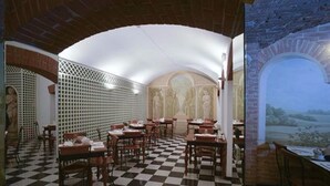 A restaurant with a checkered floor, brick arches, and a mural on the wall. - Zanhotel Tre Vecchi (Bologna)