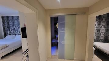 Una habitación de hotel con una cama, un armario y un baño visible a través de una puerta de cristal.
