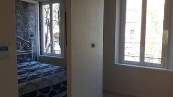 Una camera da letto con un letto, una finestra e un termostato a parete.