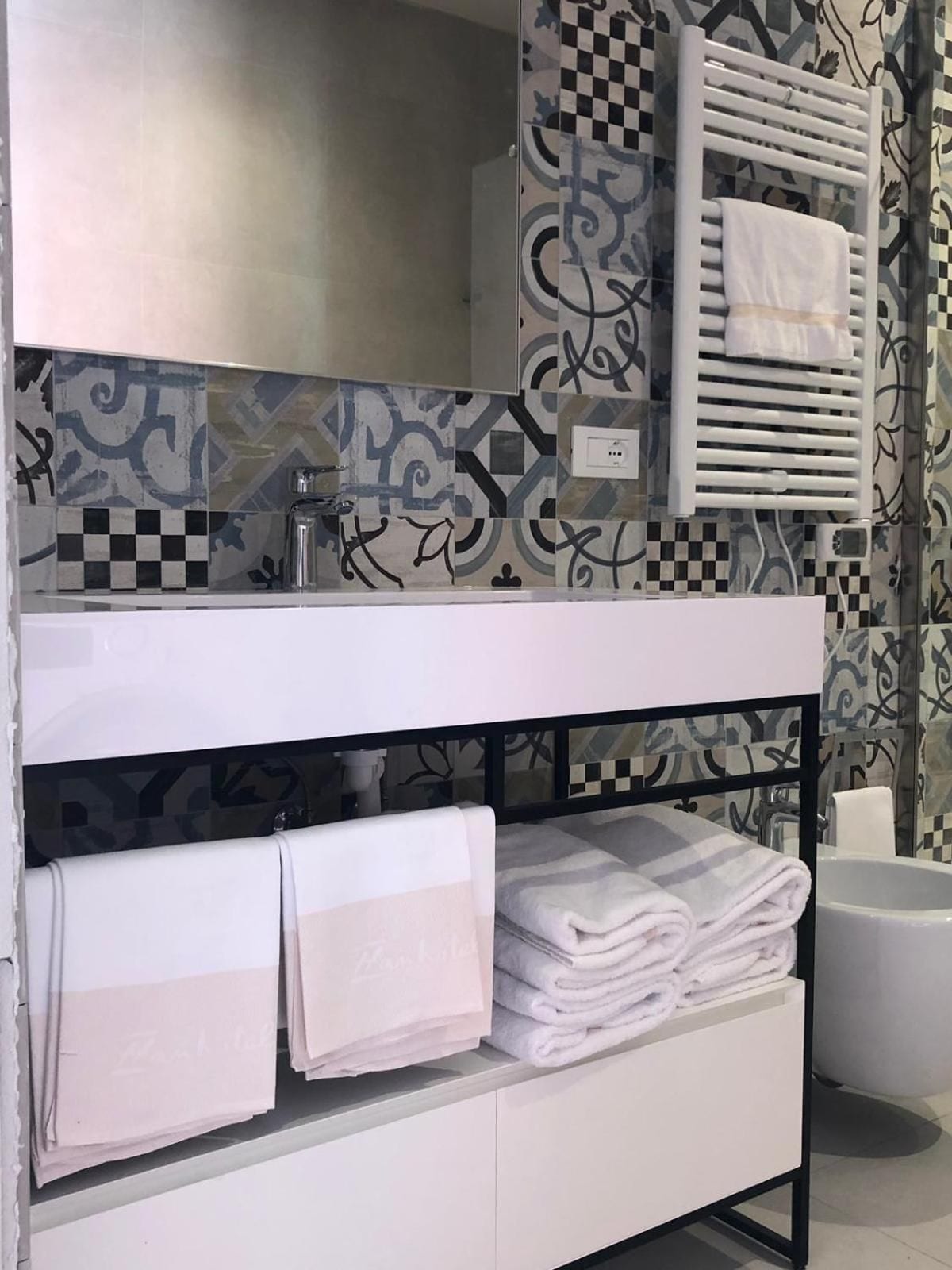 Un bagno con un mobile lavabo bianco, un portasciugamani e un lavandino.