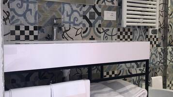 Un bagno con un mobile lavabo bianco, un portasciugamani e un lavandino.