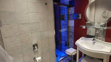 Ein modernes Badezimmer mit Toilette, Waschbecken und Duschbereich.