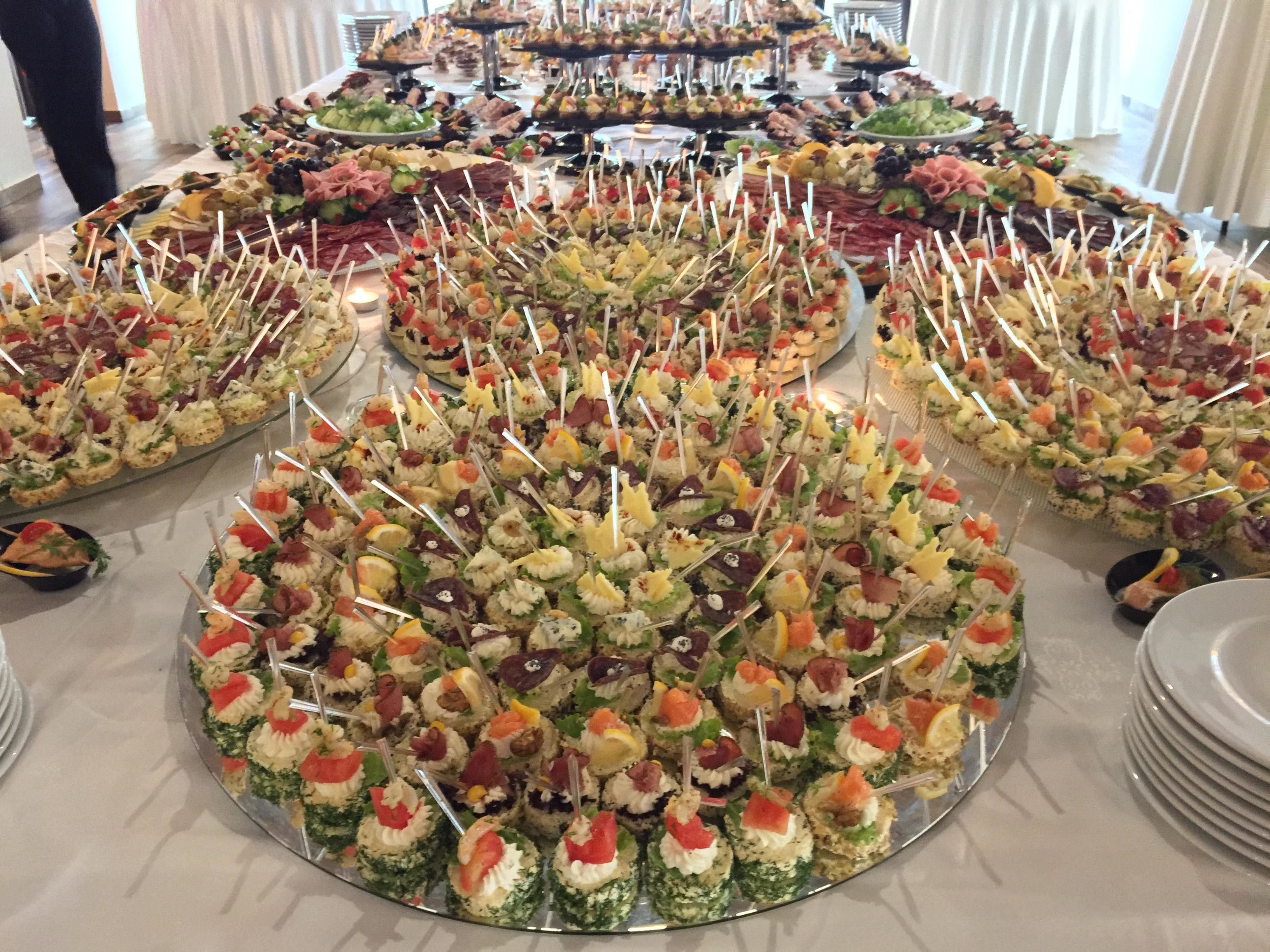 A buffet table with various food items arranged in trays.