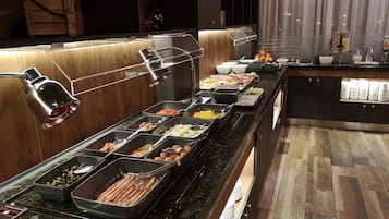 Un bufé con diversos alimentos y un árbol de Navidad al fondo.