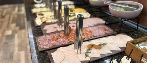 A buffet with various food items including meats, cheeses, and appetizers.