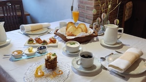 Una mesa dispuesta para el desayuno, con pan, bollería y café.