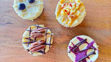 Four cupcakes on a wooden board.