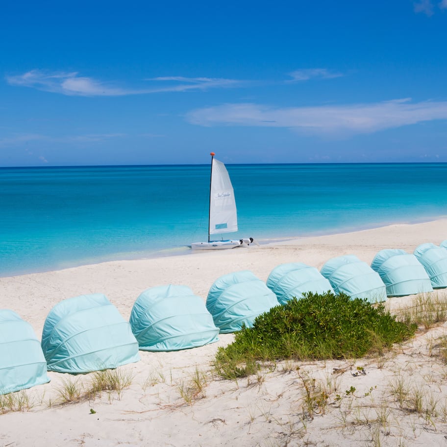 On the beach, white sand, sun loungers, beach towels