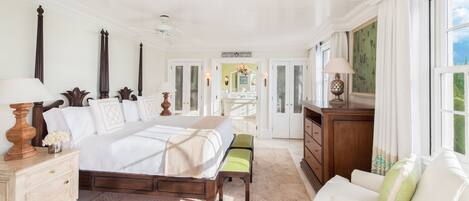 Un dormitorio amplio con una cama grande, mesitas de noche, un aparador y una silla.