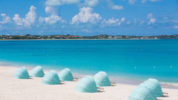 On the beach, white sand, sun-loungers, beach towels