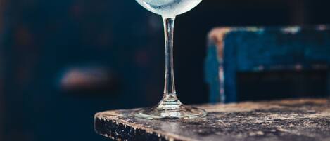 Un vaso transparente con una bebida azul sobre una superficie de madera.