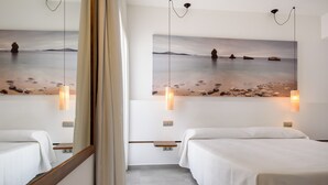 Habitación de hotel con dos camas, un cuadro grande de una playa y lámparas colgantes.