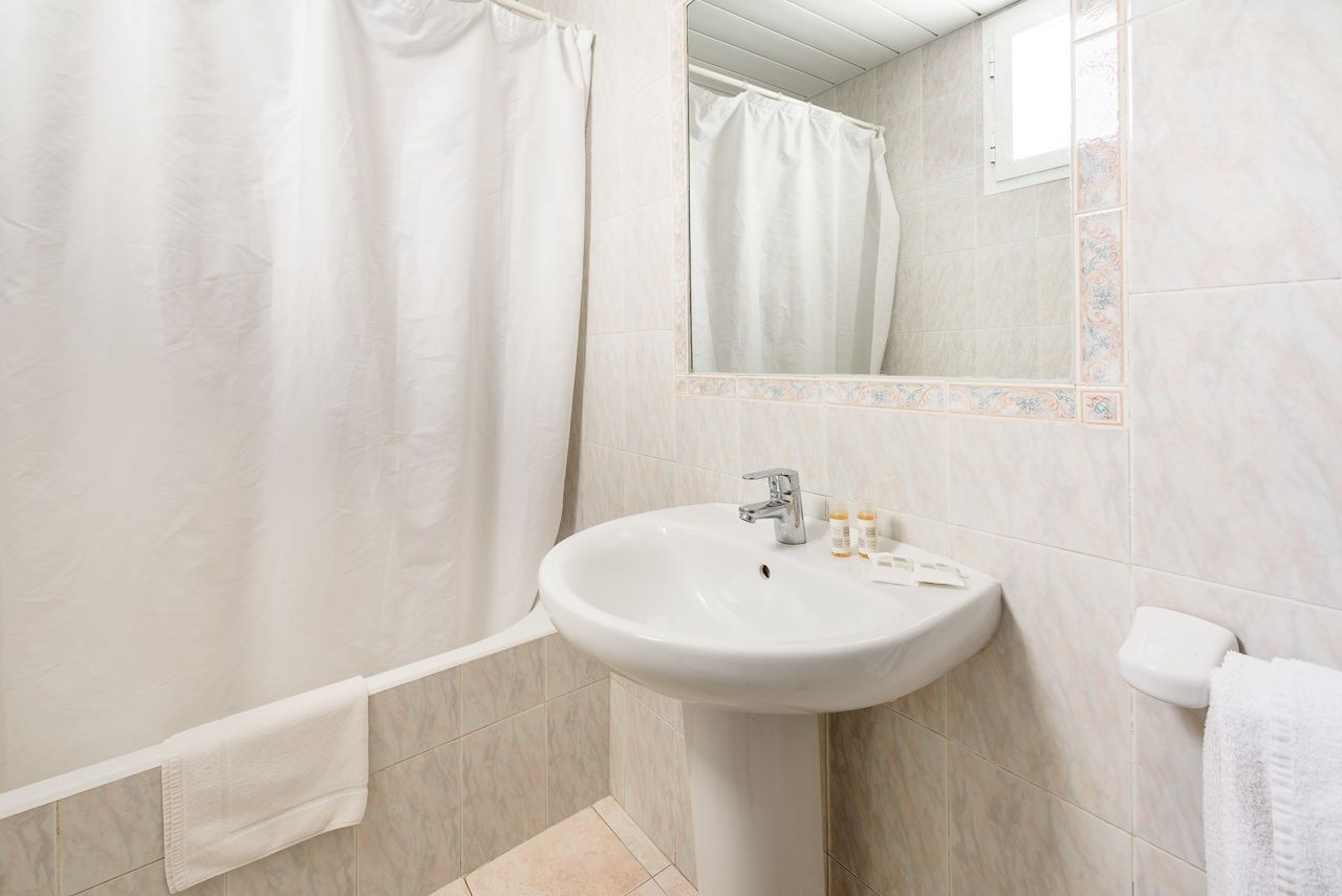 A bathroom with a bathtub, a sink, and a mirror.