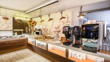 Un moderno café bar con varias máquinas de espresso, una variedad de granos de café y tazas y platillos ordenados.