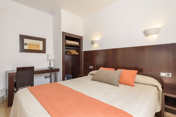 A hotel room with a bed, a desk, a chair, a wardrobe, and a mirror. - Hotel Florencio (Sant Antoni de Portmany)