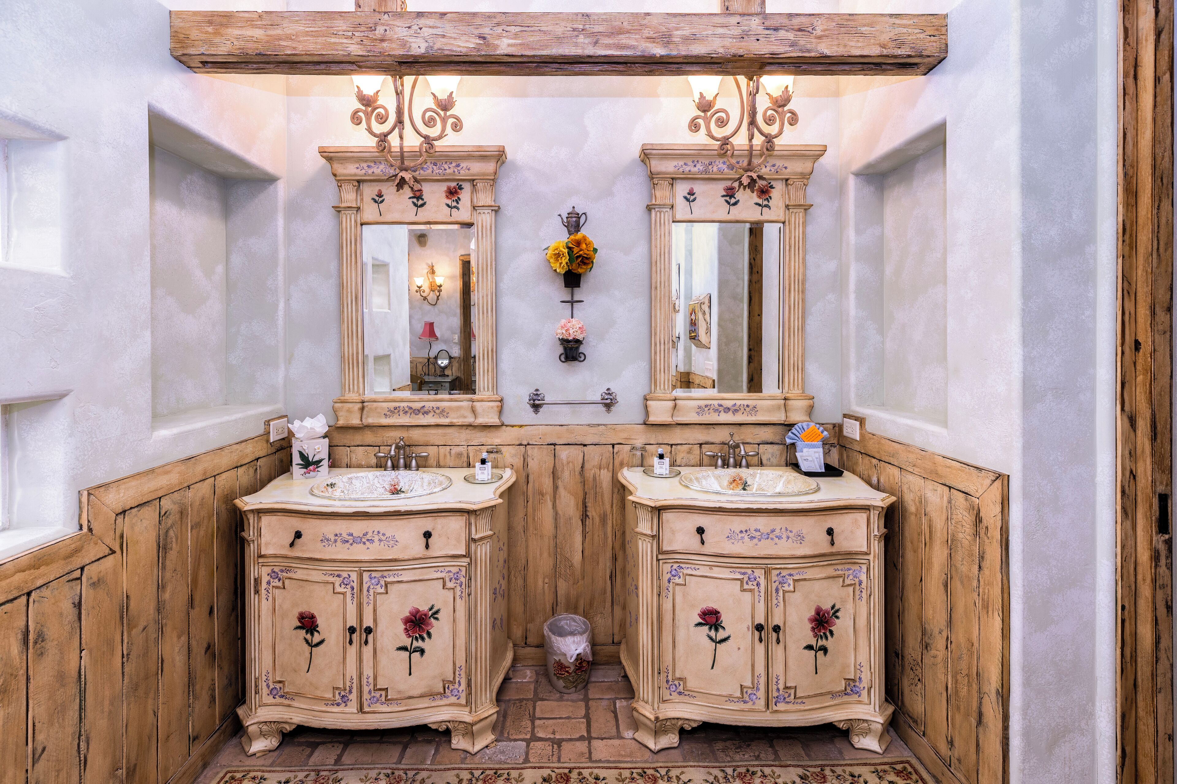 Ein Badezimmer mit zwei Waschbecken, Holzvertäfelung und dekorativen floralen Elementen.